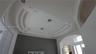 Custom tray ceiling with tiered architectural detailing, integrated recessed lighting, and arched passage entryways