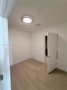 Neutral wall tones, wood-finish flooring, and a flush-mount ceiling light fixture