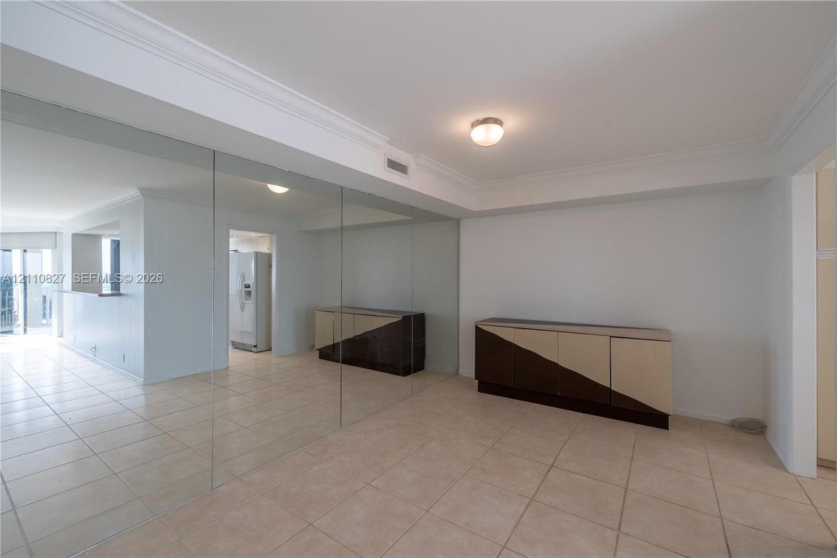 Full-wall mirror installation, ceramic tile flooring, and crown molding
