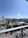 Elevated terrace featuring a metal railing with a wide-angle perspective of the surrounding cityscape, waterfront, and bridge
