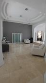 Interior space featuring polished stone flooring, recessed tray ceiling with architectural molding, and an arched entry
