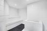 Steam room featuring white square wall tile, recessed ceiling lighting, and a built-in tiled bench