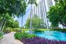 Multi-story high-rise building featuring a landscaped courtyard with a decorative pond, integrated fountains, mature palm trees, and a pedestrian foot