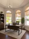 Vaulted ceiling, three arched windows, and wood-finish flooring