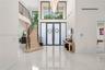 Grand foyer featuring polished large-format tile flooring, double entry doors with frosted glass panels, an expansive multi-story window, a tiered cry