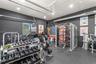 Finished garage space featuring matte black wall paint, rubberized flooring, exposed metal ductwork, and recessed lighting