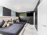 Interior space featuring large-format tile flooring, a circular flush-mount chandelier with decorative crystals, and window roller shades
