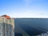 High-rise residential exterior featuring expansive glass balconies and bay water frontage