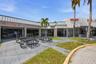 Commercial storefronts featuring metal roofing, concrete walkways, and established palm trees