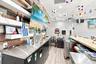 Bar area featuring stainless steel under-counter refrigeration, metal draft beer towers, wood-finish wall paneling, built-in shelving, and a bar-heigh