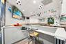 Interior space featuring recessed lighting, drop ceiling panels, wood-finish flooring, and built-in service counter with a neutral-tone surface