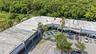 Commercial plaza featuring paved surface parking, paved exterior walkways, and mature palm landscaping