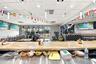 Spacious interior featuring a large service counter with a neutral-toned stone surface, recessed ceiling lighting, a dedicated bar area with structure