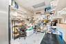 Storage area featuring multiple tiers of wall-mounted shelving and suspended ceiling panels