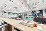 Extended service counter with solid-surface top, integrated drop ceiling with recessed lighting, and vertical slat-paneled service station