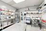 Commercial kitchen prep space featuring stainless steel upright refrigeration, an integrated ice machine, multi-tier wire shelving, and stainless stee