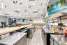 Commercial service area featuring a wooden bar top, stainless steel prep surfaces, multi-tap beverage dispensing system, and wood-finish flooring