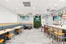 Commercial dining area featuring tile flooring, built-in wall-mounted bench seating, a wood-finish bar counter, and recessed lighting