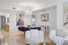 Polished stone flooring, intricate crystal statement chandelier, crown molding, and recessed wall niche