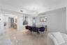 Polished stone flooring, crown molding, and a tiered crystal chandelier