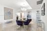 Dining area featuring polished stone tile flooring, a recessed ceiling design, and a tiered crystal chandelier