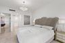 Polished stone flooring, crown molding, and crystal-accented drum pendant lighting
