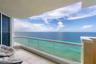 Covered balcony featuring tile flooring and a glass panel railing with a horizontal metal top rail