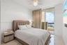Floor-to-ceiling glass sliding door with access to a balcony, polished stone flooring, and crystal-accented ceiling fan with light fixture
