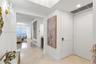 Entryway featuring polished stone flooring, recessed ceiling lighting, a crystal wall sconce, and high-gloss multi-panel doors