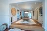 Sunken living area featuring terracotta tile flooring, wood-finish step detail, recessed lighting, and a modern pendant fixture