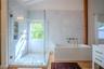 Walk-in shower with frameless glass enclosure, built-in shelving, and large-format stone tiling