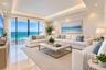 Open-concept interior featuring tray ceilings, neutral tile flooring, built-in breakfast bar, and recessed lighting