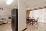 Floor-to-ceiling sliding glass doors opening to a private balcony, wood-finish flooring, and ocean backdrop