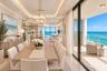 Kitchen featuring light-toned cabinetry, stone-finish countertops, stainless steel appliances, tile backsplash, and tile flooring