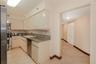 Kitchen featuring flat-panel cabinetry, light-toned stone countertops, a dark-finish double-door refrigerator, and polished stone tile flooring throug