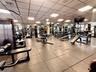 Fitness area featuring a coffered drop ceiling, expansive wall-to-wall mirrors, and durable rubberized flooring