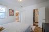 Neutral wall palette with crown molding, double-door closet, terracotta-style tile flooring, and en suite bathroom featuring a glass-enclosed shower