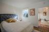 Neutral-toned room featuring crown molding, a window with a roller shade, and tile flooring