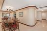 Dining area featuring an ornate multi-arm chandelier, built-in wet bar with mirrored backsplash, and floor-to-ceiling sliding glass doors opening to a