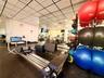 Flexible interior room featuring durable speckled flooring, recessed lighting, and wall-mounted shelving
