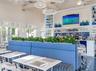 Vaulted ceilings with exposed beams, built-in recessed shelving, decorative pendant lighting, louvered window panels, and integrated bar service area