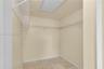 Storage area featuring tile flooring, white wire shelving, and an integrated ceiling access panel