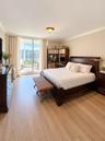 Room featuring wood-finish flooring, crown molding, and floor-to-ceiling glass sliding doors opening to a balcony