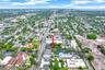 Aerial view featuring a designated parking lot and mature tree canopy, positioned within a metropolitan urban grid