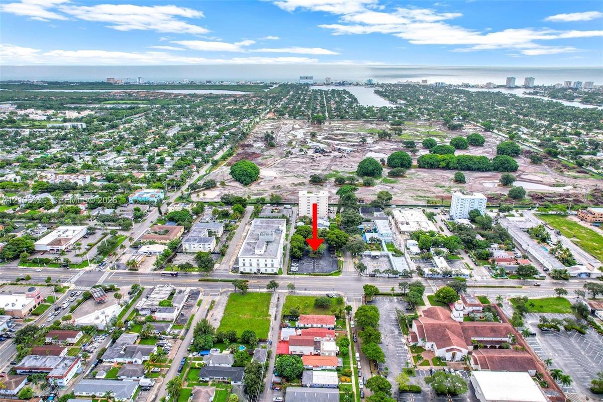 Aerial perspective of a paved parking lot situated within a developed urban grid