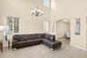 Vaulted ceilings featuring a multi-arm chandelier, neutral tile flooring, and arched architectural wall cutouts