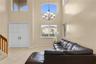 Double-height ceilings, arched transom windows, tile flooring, multi-light chandelier, and double-door entry