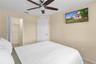 Neutral interior featuring a ceiling fan with integrated lighting, a walk-in closet, and a multi-panel interior door