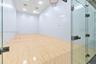 Recreational court featuring wood-finish flooring, high-impact walls, glass enclosure, and overhead recessed lighting