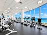 Fitness center featuring floor-to-ceiling windows, panoramic ocean scenery, recessed lighting, and rubberized flooring